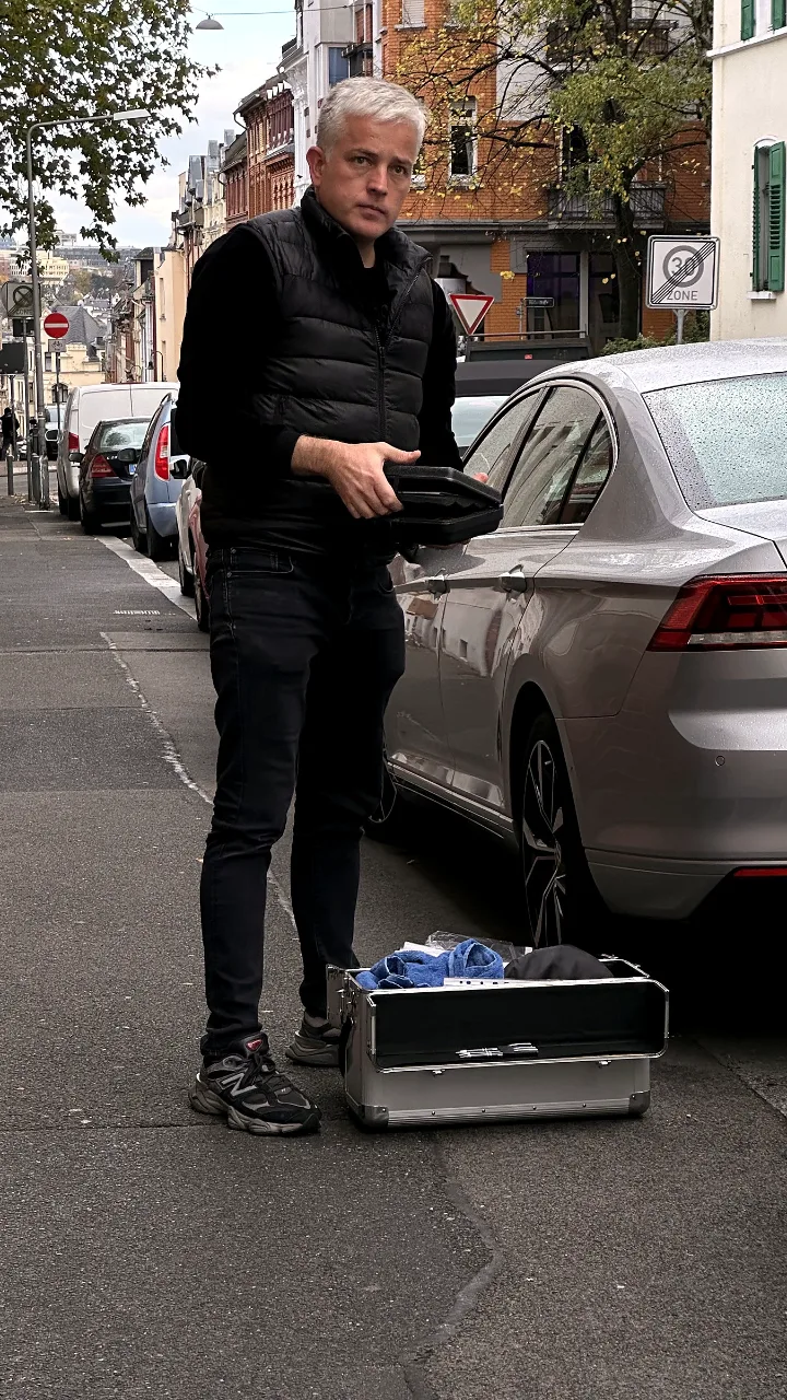 Kfz-Sachverständiger Dipl.-Ing. Adam Spiczak mit Gutachterkoffer bei der Fahrzeugbesichtigung